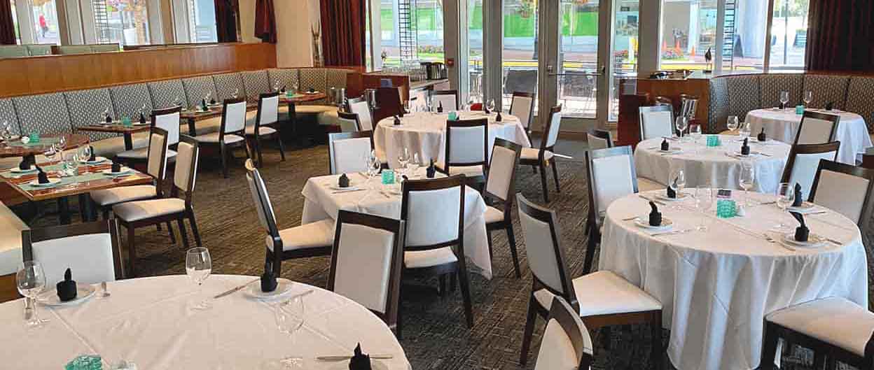 tavoli e sedie in uno spazio da pranzo aperto e moderno