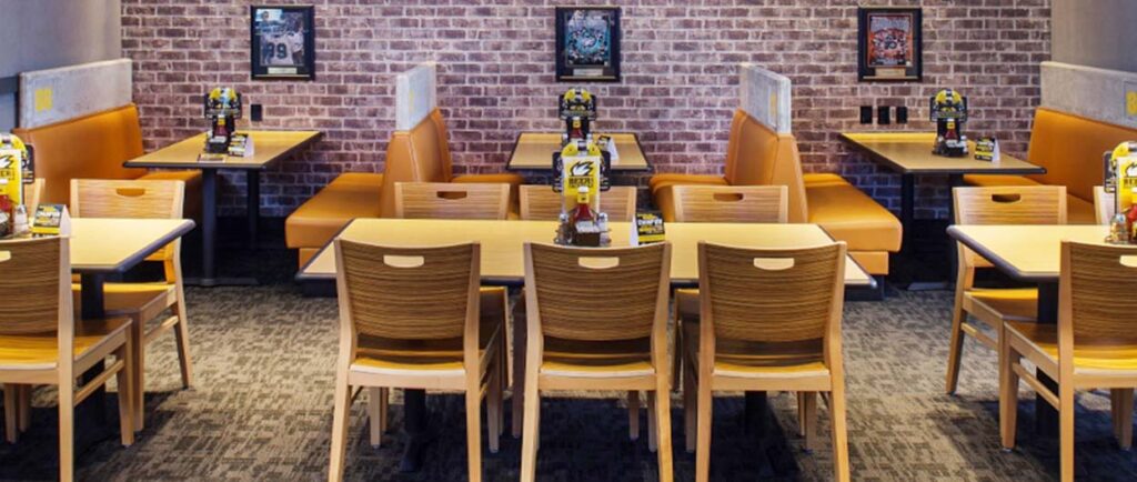 Cadeiras de madeira Holsag em um ambiente de bar esportivo