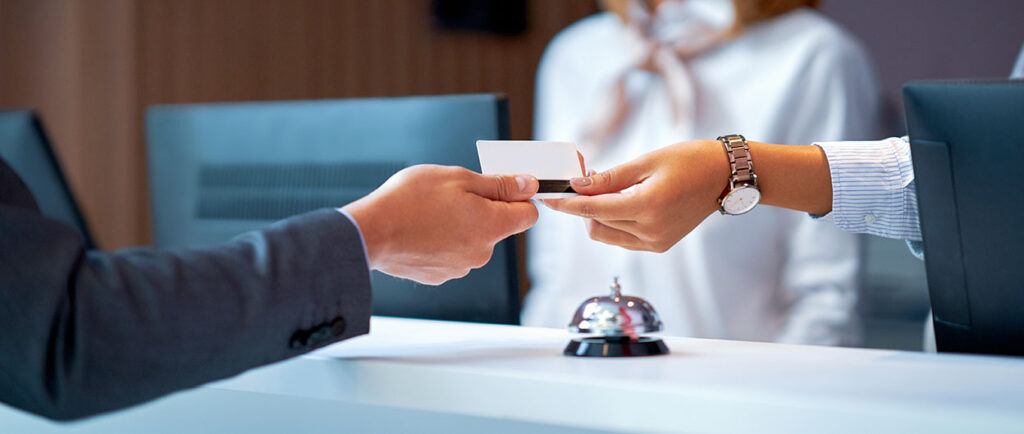 Nahaufnahme einer Transaktion an einem Hotelschalter